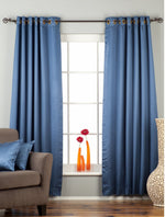 Blue sari grommet top curtains hung at a window