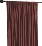 Wine velvet rod pocket curtains hung at a window