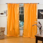 Pumpkin sari tie top curtains hung at a window
