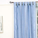 Light blue velvet tab top curtains hung at a window