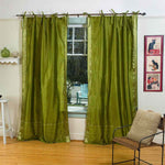 Olive green sari tie top curtains hung at a window