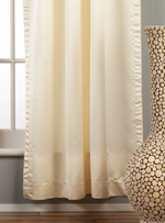 Cream sari rod pocket curtains hung at a window