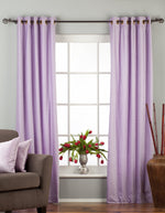 Lavender velvet grommet top curtains hung at a window