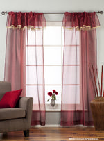 Maroon sheer tissue rod pocket curtains hung at a window