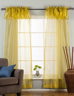 Gold sheer tissue rod pocket curtains hung at a window