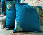 Turquoise sari cushion covers arranged on a sofa