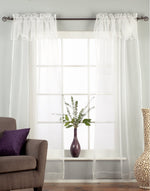White sheer tissue rod pocket curtains hung at a window