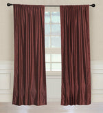 Wine velvet rod pocket curtains hung at a window