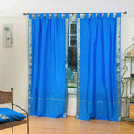 Blue sari tab top curtains hung at a window