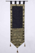 Black sari wall hanging displayed on a wall