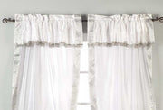 Cream sari rod pocket curtains hung at a window