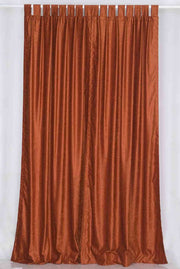 Rust velvet tab top curtains hung at a window