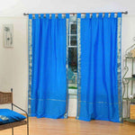 Blue sari tab top curtains hung at a window