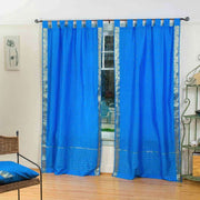 Blue sari tab top curtains hung at a window