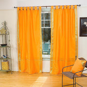 Pumpkin sari tab top curtains hung at a window