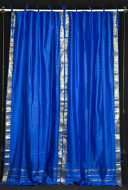 Blue sari tie top curtains hung at a window