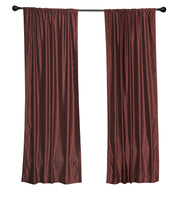 Wine velvet rod pocket curtains hung at a window
