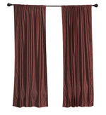 Wine velvet rod pocket curtains hung at a window