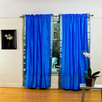 Blue sari rod pocket curtains hung at a window