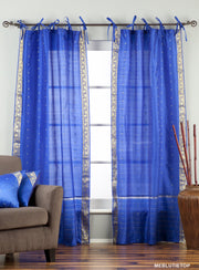 Blue sari tie top curtains hung at a window