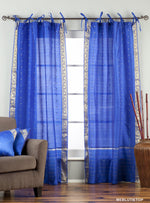Blue sari tie top curtains hung at a window