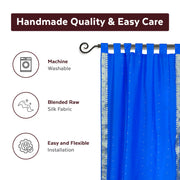Blue sari tab top curtains hung at a window