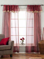 Maroon sheer tissue rod pocket curtains hung at a window