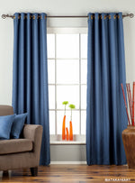 Blue raw silk ring top curtains hung at a window