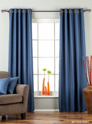 Blue raw silk ring top curtains hung at a window