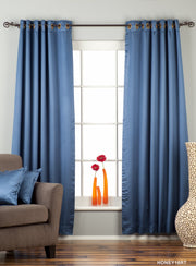 Blue sari grommet top curtains hung at a window