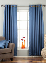 Blue sari grommet top curtains hung at a window