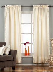 Cream sari rod pocket curtains hung at a window