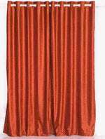 Rust velvet grommet top curtains hung at a window