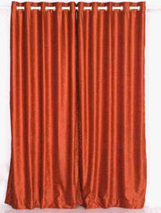 Rust velvet grommet top curtains hung at a window