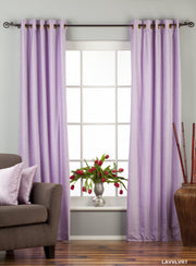 Lavender velvet grommet top curtains hung at a window