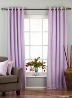 Lavender velvet grommet top curtains hung at a window