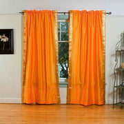 Pumpkin sari rod pocket curtains hung at a window