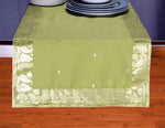Olive green silk table runner running down a dining table