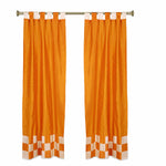 Orange sari tab top curtains hung at a window