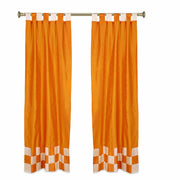 Orange sari tab top curtains hung at a window