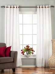 White velvet grommet top curtains hung at a window