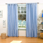 Light blue velvet tab top curtains hung at a window