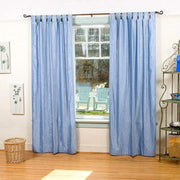 Light blue velvet tab top curtains hung at a window