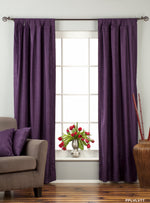 Purple velvet tab top curtains hung at a window