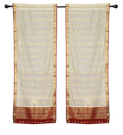 Cream sari rod pocket curtains hung at a window