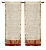 Cream sari rod pocket curtains hung at a window