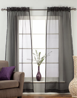 Black sheer tissue rod pocket curtains hung at a window