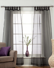 Black sheer tissue tab top curtains hung at a window