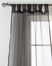 Black sheer tissue tab top curtains hung at a window