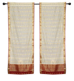Cream sari rod pocket curtains hung at a window